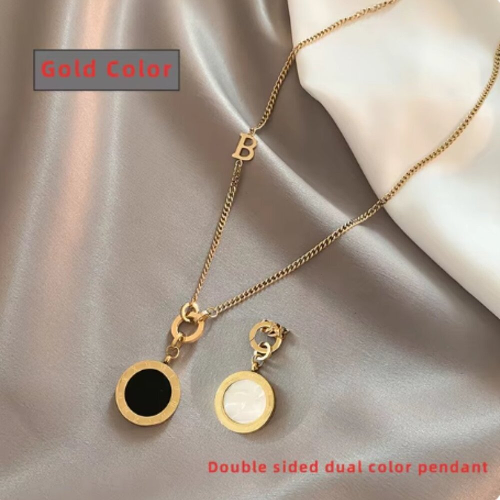 Golden necklace with  black and  white dual sided pendant.